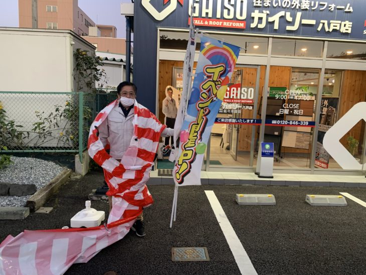 外壁塗装 ショールームオープン2周年祭の紅白幕回収 店長ポーズ